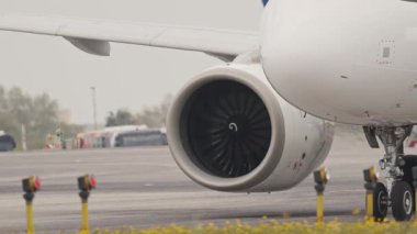 Bir havaalanı pistinde vergilendirilirken çalışan yolcu uçağı motoru