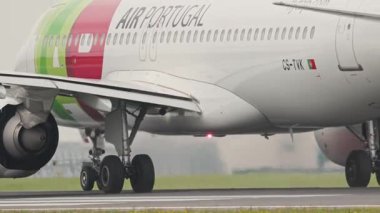 10 Nisan 2025, Lizbon, Portekiz - Bir havaalanı pistinde beyaz ve yeşil pist Portekiz Airbus a320 taksicilik