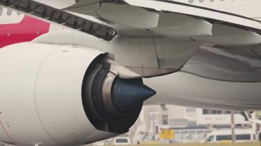 Havaalanı pistinde büyük bir yolcu uçağı motoru ve kanadının görüntüsünü kapat.