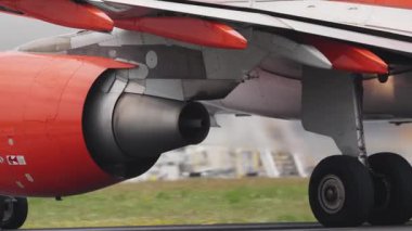 Pistte taksicilik yapan turuncu ve beyaz bir uçak motorunu kapat.