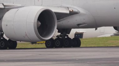 Yolcu uçağı motoru ve iniş takımları bir havaalanı pistinde hareket ediyor.