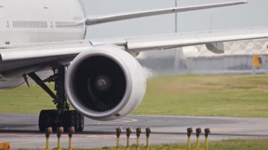 Beyaz uçak pistte uçarken buharı tüketiyor.