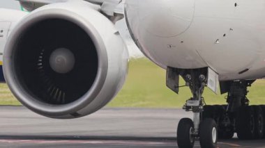 Pistte büyük bir yolcu uçağı motoru ve iniş takımının görüntüsünü kapatın.