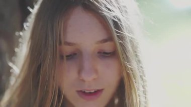 Güneş ışığında saçlara dokunan genç bir kadın, altı panelli kurgu.