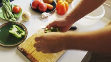 Şef ahşap kesme tahtasında yeşil dolma biber hazırlıyor.