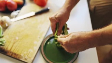 Şef yeşil bir dolma biberi tabakta ki tohumlardan temizler.