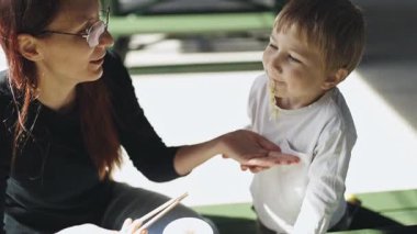 Sevgili anne öğle yemeği sırasında oğluna erişte yedirir.