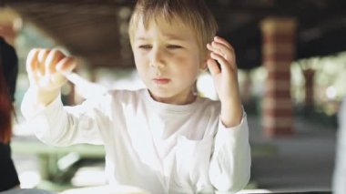 Annem parkta piknik yaparken oğluna bir parça meyve veriyor.