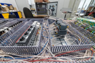 Montaj altındaki bir elektrik kabininin yakın plan görüntüsü, karmaşık bir kablo ve devre kesiciler ağını ortaya çıkarıyor