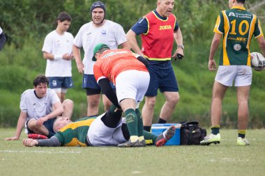 3 Mayıs 2025, Lisbon. Portekiz - oeiras vs ag - Maç sırasında sahada yaralanan rugby oyuncularına tıbbi personel, endişeli takım arkadaşlarıyla çevrili