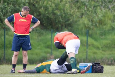 3 Mayıs 2025, Lisbon. Portekiz - oeiras vs ag - bir maç sırasında sahada yaralı rugby oyuncusuna yardım eden tıbbi personel, koç ise bu konuda endişeli