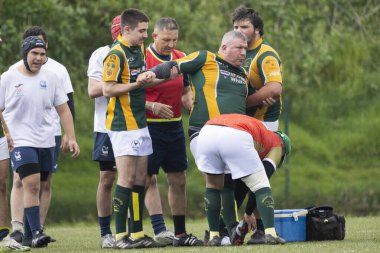 3 Mayıs 2025, Lisbon. Portekiz - oeiras vs ag - yaralı rugby oyuncusu, takım arkadaşları ve sağlık personeli tarafından çevrili bir oyun sırasında sahada tıbbi yardım alıyor.