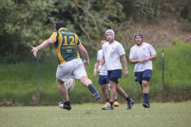 3 Mayıs 2025, Lisbon. Portekiz - oeiras vs ag - Rugby oyuncusu arka planda diğer oyuncularla birlikte bir maç sırasında topa vuruyor