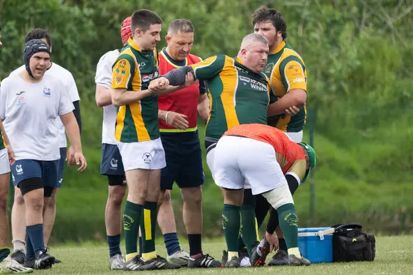 3 Mayıs 2025, Lisbon. Portekiz - oeiras vs ag - yaralı rugby oyuncusu, takım arkadaşları ve sağlık personeli tarafından çevrili bir oyun sırasında sahada tıbbi yardım alıyor.