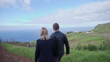 Sahil yolunda el ele yürüyen bir çift.