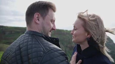 Sevecen bir çift okyanusa bakan manzaralı bir uçurumda samimi anlar paylaşıyor.