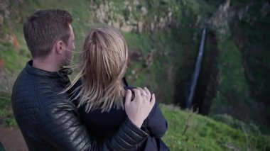 Şelale manzarasını kucaklayan ve hayran bırakan romantik çift