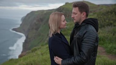 Okyanus manzaralı, manzaralı bir uçurumda kucaklaşan sevgi dolu bir çift.