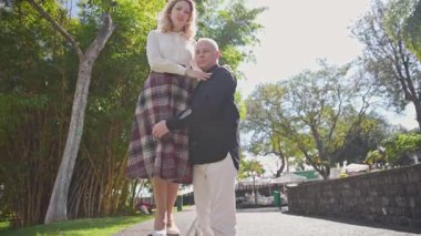 Mutlu olgun turistler, güzel şehir bahçesinde sevgi gösteriyorlar.