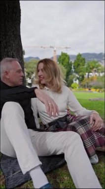 Romantik olgun çift parkta huzurlu bir günün tadını çıkarıyor, sevgi ve bağlarını ifade ediyorlar.