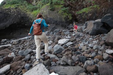 Anne ve oğlu kayalık plajları keşfediyor, volkanik adalarda doğa yürüyüşünün tadını çıkarıyor.
