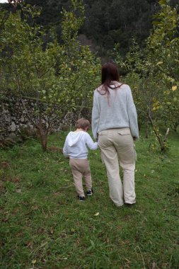 Anne ve oğlu kırsalda yürüyüş yapıyor, doğayı keşfediyor ve birlikte kaliteli zaman geçiriyorlar.