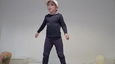 Enerjik çocuk çeşitli dans hareketleri ve zıplamalar yapıyor, neşe ve özgürlüğü ifade ediyor.