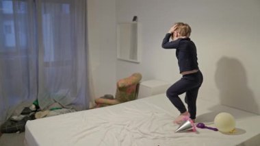 Pijamayla yatakta dans eden mutlu çocuk.