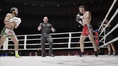 8 Mayıs 2025, Lizbon, Portekiz kickboks müsabakası iki muay thai dövüşçüsü şiddetli bir maçta güçlü tekmeler ve yumruklaşmalar yapıyorlar.