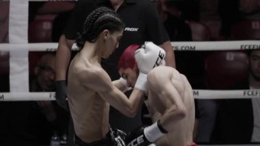 8 Mayıs 2025, Lizbon, Portekiz kickboks müsabakası örgülü ve kızıl saçlı iki boksör bir boks maçında dövüşüyor.