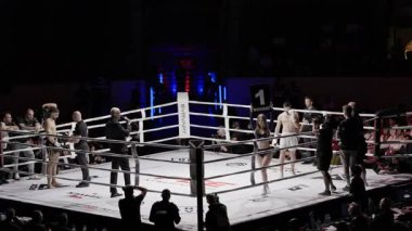 8 Mayıs 2025, Lizbon, Portekiz kickboks müsabakası kadın hakem boks ringinde dövüşçü kolunu kaldırıyor ve onu kickboks maçının galibi ilan ediyor.