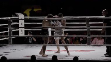 8 Mayıs 2025, Lizbon, Portekiz kickboks müsabakası iki muay thai dövüşçüsü, bir hakem tarafından denetlenen bir maç sırasında karşılıklı tekmeleme ve yumruklaşma.