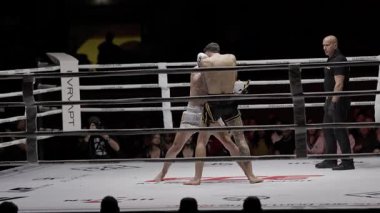 8 Mayıs 2025, Lizbon, Portekiz kickboks müsabakası bir hakem tarafından gözlemlenen bir maç sırasında iki muay thai dövüşçüsü yumruk yumruğa dövüşüyor.