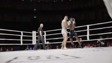8 Mayıs 2025, Lizbon, Portekiz kickboks müsabakası. İki muay thai dövüşçüsü bir boks ringinde dövüşüyor. Güçlü yumruklar ve tekmeler.