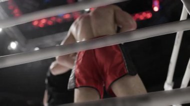 Boksör rauntlar arasında boks ringinin köşesinde bekliyor.