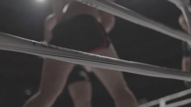 Boksör boks maçı sırasında ringin köşesine doğru yürür.