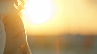 Güzel genç bayan, altın saat güneş ışığının tadını çıkarıyor