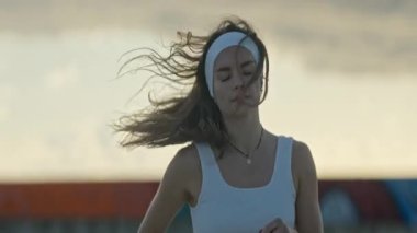 Zarif kadın tai chi yapıyor, hafif bir esintinin ortasında sükuneti kucaklıyor.