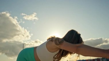 Spor kadını gün doğumunda yoga yapıyor.