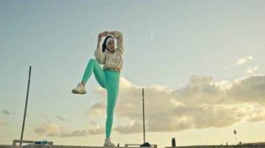 Spor salonundaki kadın dışarıda esneme egzersizleri yapıyor.