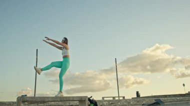 Fitness modeli beton blokta bacak kaldırma egzersizi yapar