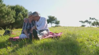 Yaşlı bir çift piknik sırasında hassas bir anı paylaşıyor. Emeklilikte sevgi ve arkadaşlık gösteriyorlar.