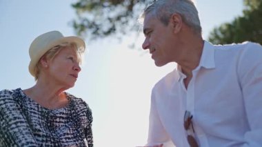 Yaşlı çift dışarıda ciddi bir konuşma yapıyor, düşüncelerini ve duygularını ifade ediyorlar.