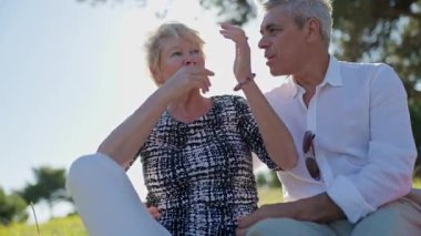 Mutlu yaşlı çift güneşli bir parkta romantik bir piknik yapıyor.