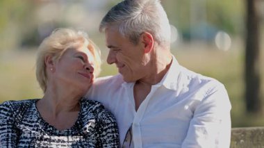 Yaşlı bir çift parktaki bankta eğleniyor.