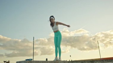 Enerjik kadın dinamik atlama egzersizleri sergiliyor.