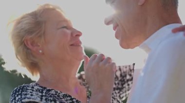 Yaşlı çift dışarıda romantik bir anın tadını çıkarıyor.