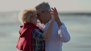 Yaşlı bir çift sahilde romantik bir tango yapıyor.