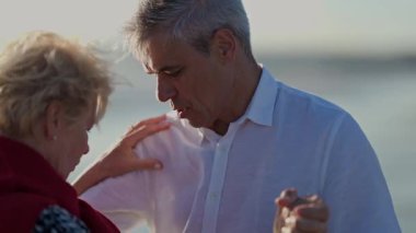 Yaşlı bir çift sahilde tango yapıyor.