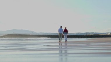 Emekli çift sahilde romantik yürüyüşlerden hoşlanır.